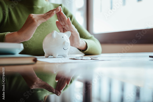 Protecting Savings with Piggy Bank and Hands in Financial Security Concept