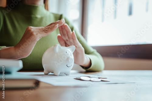 Protecting Savings with Piggy Bank and Hands in Financial Security Concept