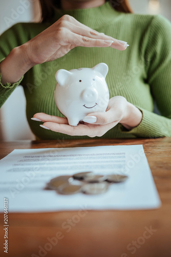 Protecting Savings with Piggy Bank and Hands in Financial Security Concept