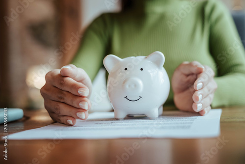 Protecting Savings with Piggy Bank and Hands in Financial Security Concept