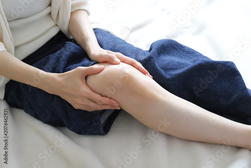 Bild auf Leinwand 膝の痛みを感じて膝を押さえる女性