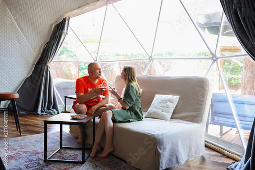 Obraz na plátně Couple unwinding on a sofa inside a bright geodesic dome accommodation