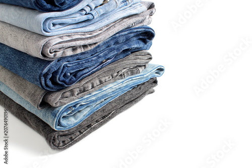 There is a stack of folded jeans on a white background.