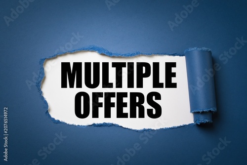 Multiple offers written on white paper revealed by torn dark blue paper