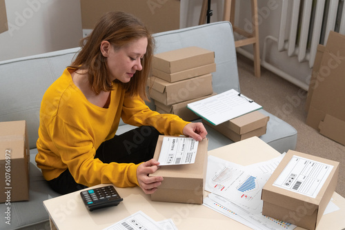 Εκτύπωση καμβά Logistics worker attaching barcode label on cardboard parcel in delivery service office