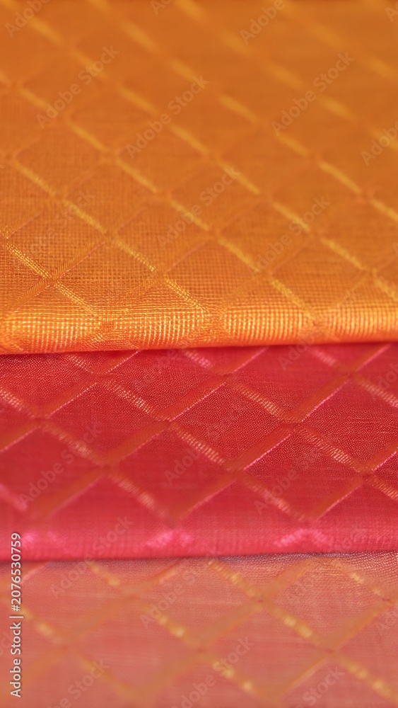 Fototapeta premium Orange and pink satin quilted fabric texture with diamond pattern