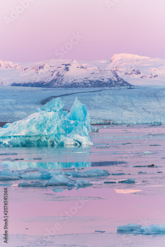 Blue icebergs floating in Jokulsarlon glacial lagoon at pastel sunset