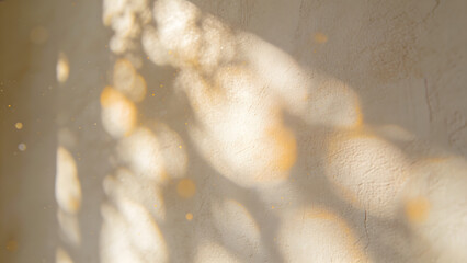 Soft golden light patterns on textured beige wall with bokeh particles