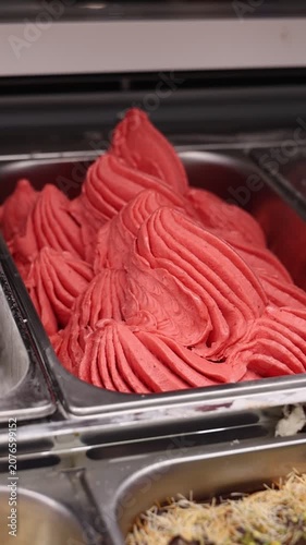 Supermarket ice cream shelf with various flavors and brands, retail food concept.