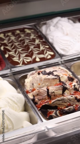 Supermarket ice cream shelf with various flavors and brands, retail food concept.