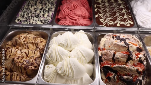 Supermarket ice cream shelf with various flavors and brands, retail food concept.