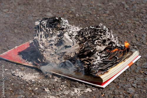 Burning book on fire with ashes symbolizing censorship and freedom of speech