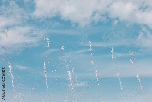 Fountain Water Jets Spraying Against Blue Cloudy Sky