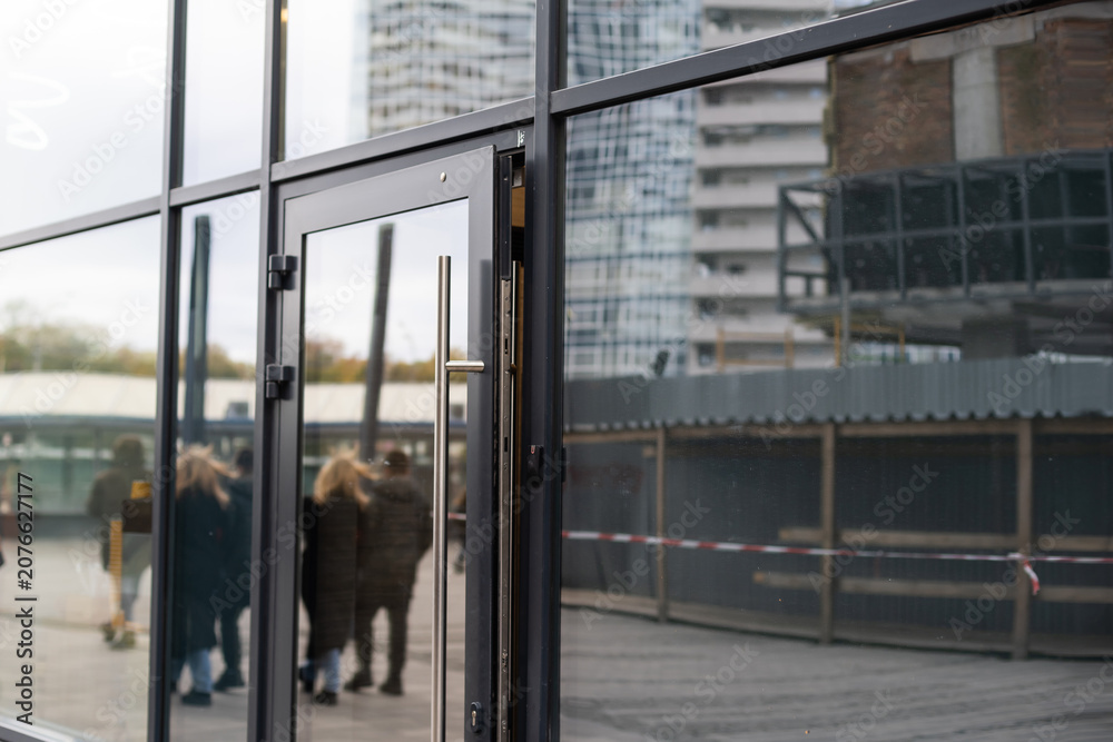 Fototapeta premium Outside solid glass door with building exterior