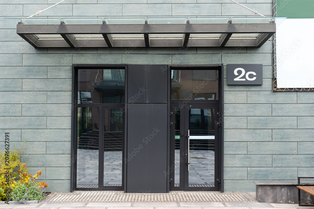 Fototapeta premium Outside solid glass door with building exterior