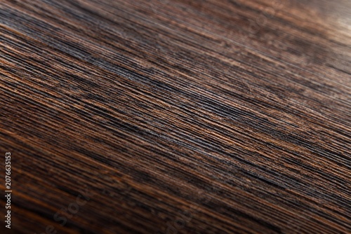 Extreme close-up of the metallic wood grain on a dark brown board.