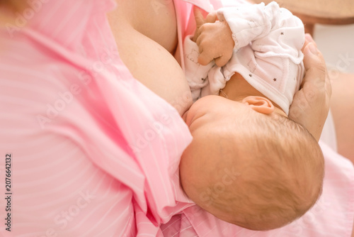 Close-up of a baby with its mother drinking breast milk. Proper nutrition and feeding of newborns.
