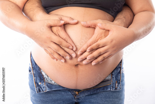 Pregnant big belly parents holding the baby making a heart shape with hands