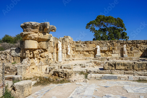 Ruins of the ancient city of Salamis, North Cyprus. The image shows marble statues, typical of Greco-Roman architecture. The statues, lacking heads, are draped in classical attire.