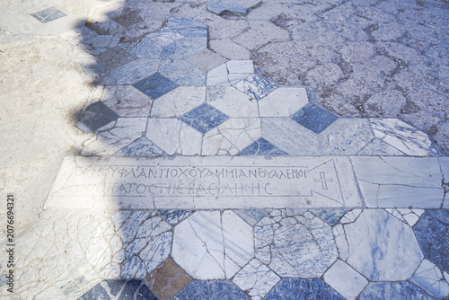 Mosaic pathway from the ancient city of Salamis, North Cyprus.  The surface includes an inscription in Greek with a Christian cross symbol, indicative of historical religious significance. 