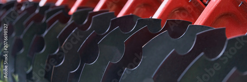 Agricultural Disc Harrow Blades Aligned On Red Frame In Close Up Detail Showing Curved Steel Discs Mounted On Farm Machinery For Soil Tillage And Implement Maintenance.