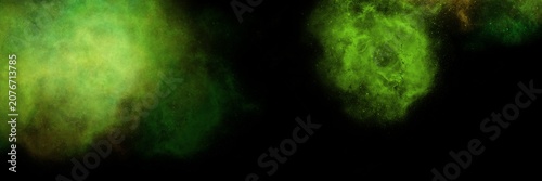 Fotografía Bright green and yellow smoke rising from the bottom of a dark background