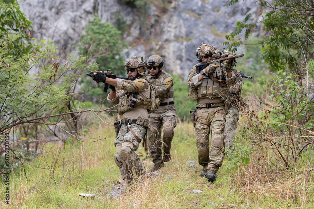 Fototapeta premium Military participate in a patrol in forrest terrain
