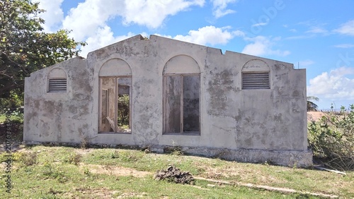 Foto Abandoned concrete house structure in a rural landscape under blue sky
