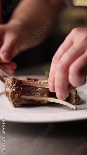 Chef preparing grilled New Zealand lamb ribs in a premium restaurant kitchen. Close-up of juicy meat, fire grill and gourmet cooking process