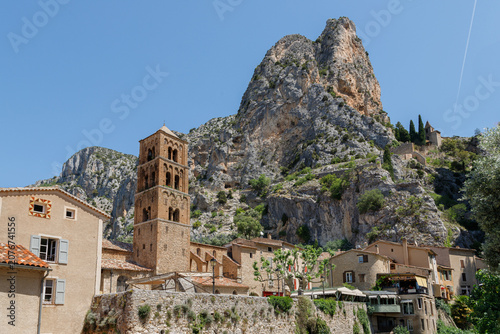 Historic mountain village Moustiers-Sainte-Marie in Provence under blue sky.