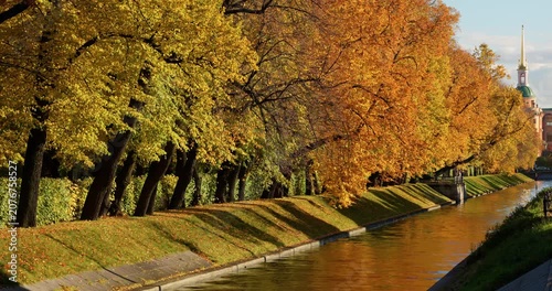 Lebyazhya kanavka embankment to the engineering palace, Trees with yellow leaves of the Summer garden in sunny autumn evening, Russia, Saint Petersburg