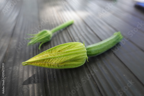 Obraz na płótnie Freshly picked zucchini vegetable with a vibrant green flower bud and stem layin
