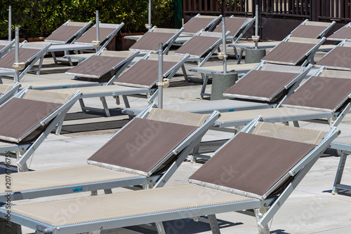 Many identical sun loungers arranged in even rows outdoors.