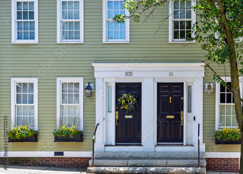 Historic green clapboard house with double black front doors and flower boxes in Charlestown, Boston, USA
