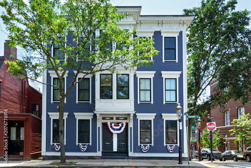 Blue clapboard residential building with white trim decorated with patriotic bunting flags in Charlestown, Boston, USA
