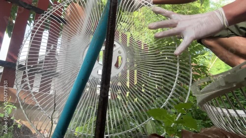 Water from pipe flow freely cleaning dirt and dust form fan grill and blade at home outdoor