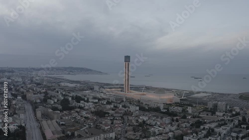 High-angle drone footage capturing the imposing scale of Djamaa el Djazair and its massive minaret dominating the Algerian capital's coastal landscape.