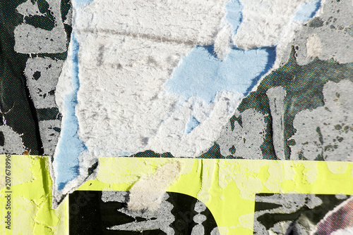 Old colorful ripped torn grunge advertising posters on wall background