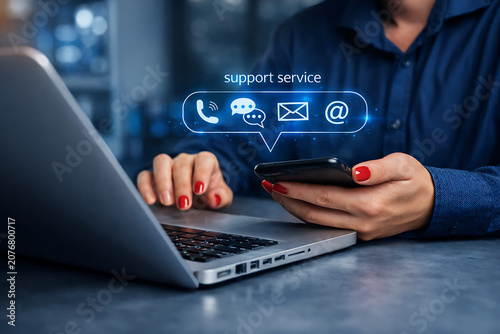 Customer support icons hovering over a person's hands holding a smartphone and using a laptop