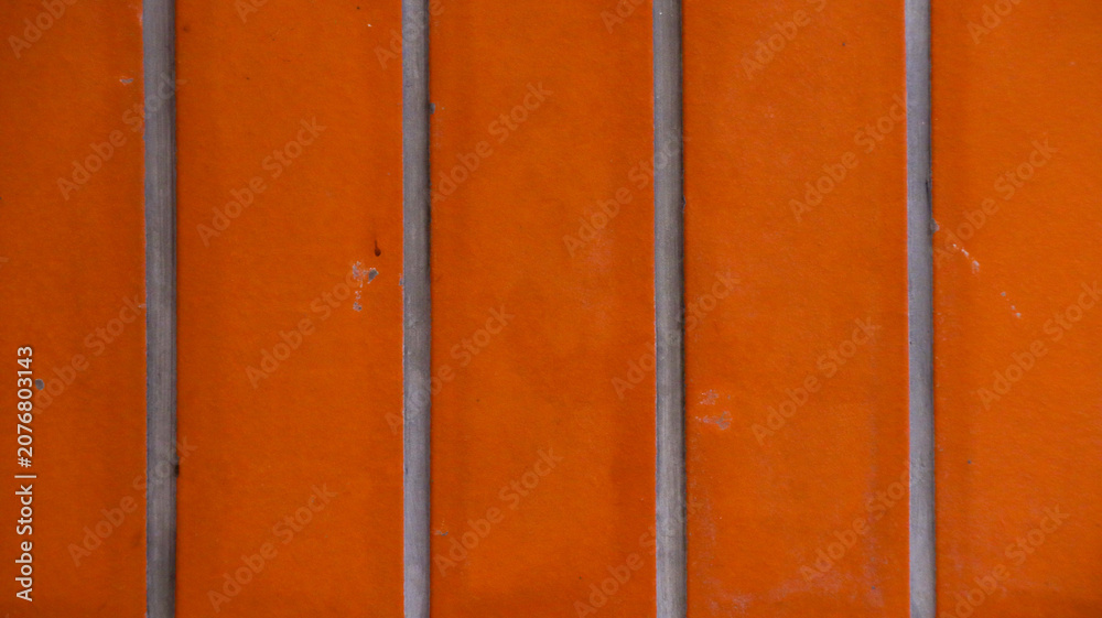 Fototapeta premium Vibrant Orange Wall Texture With Vertical Gray Dividers