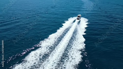 Speedboat creating white wake in blue ocean.