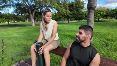 A couple of friends chatting in the park after a workout