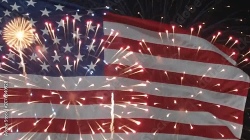 American flag waving with bright colorful fireworks display in the night sky during independence day celebration