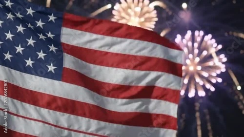 American flag waving against a background of festive fireworks at night