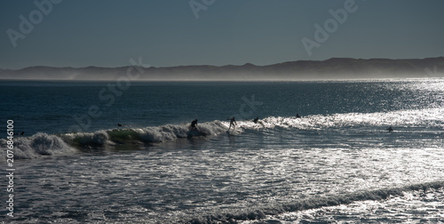 Surfers surfing in Raglan New Zealand