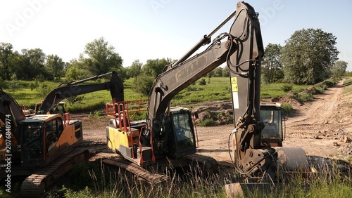 Obraz na plátně Ciężkie maszyny budowlane, w tym gąsienicowe koparki, zaparkowane na placu budowy