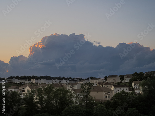 Massive thunderhead storm cloud looming behind a Pennsylvania residential suburb