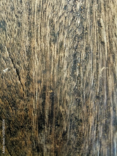Close up of old dark brown wooden plank surface with deep vertical grain lines and weathered aged rustic texture pattern background  