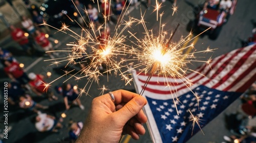 Hand holding sparklers at a fourth of july parade