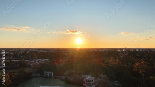 Adelaide, South Australia – 4K aerial drone footage of golden sunset over parklands, urban skyline, city suburbs, eucalyptus trees and evening landscape.